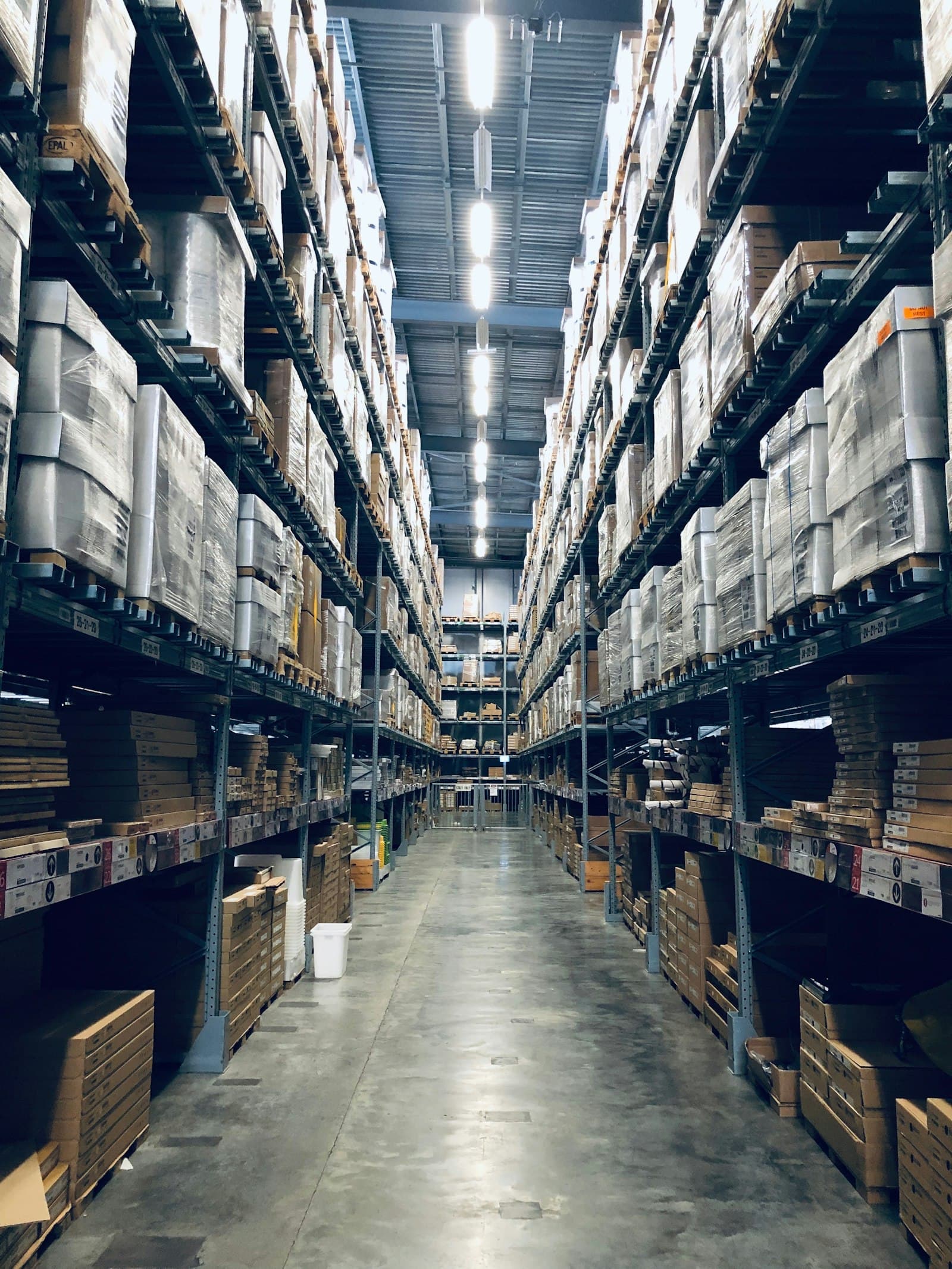 Pallet truck ในคลังสินค้าระหว่างเคลื่อนย้ายพาเลทสินค้า — เปรียบเทียบ Pallet Truck vs Forklift